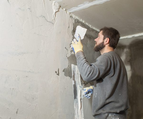 Een stukadoor werkt een wand glad af